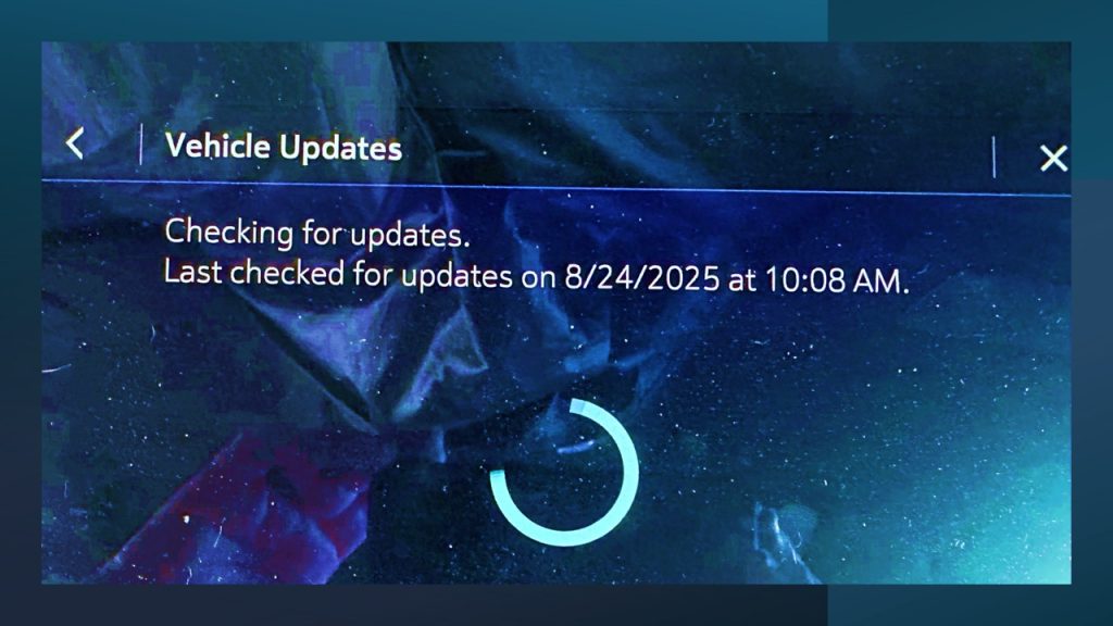 Vehicle touchscreen displaying an in-car software update screen with status message ‘Checking for updates’ and last update check timestamp, illustrating modern connected-car technology.