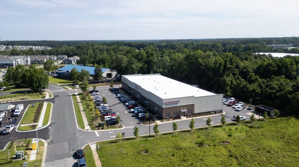 Aerial view of Getz Automotive facility with parking lot and surrounding greenery in a suburban business park.