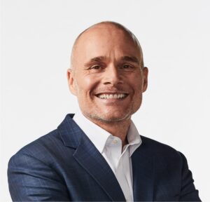 Steve Greenfield smiling in a blue checkered suit and white shirt, representing automotive data expertise and industry thought leadership.